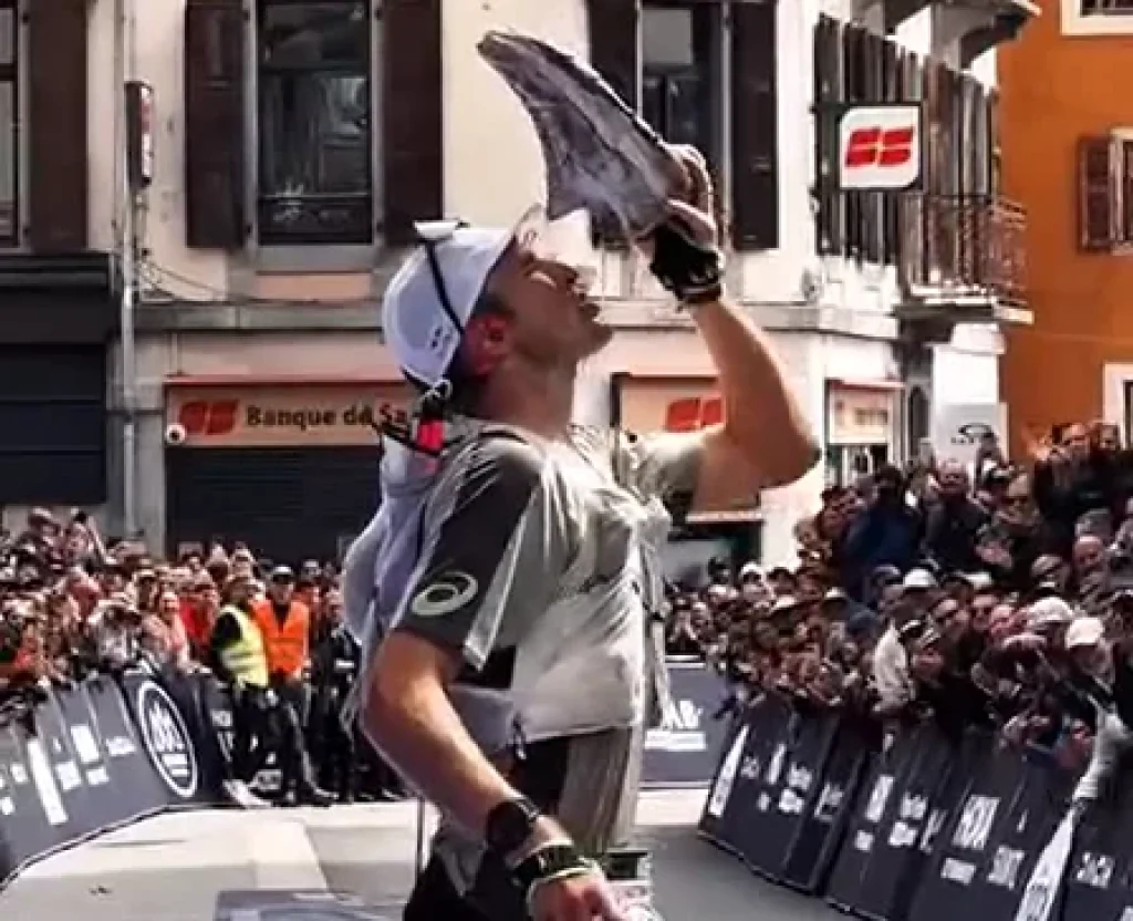 Le vainqueur de l'UTMB 2025 Tom Evans boit dans sa chaussure.